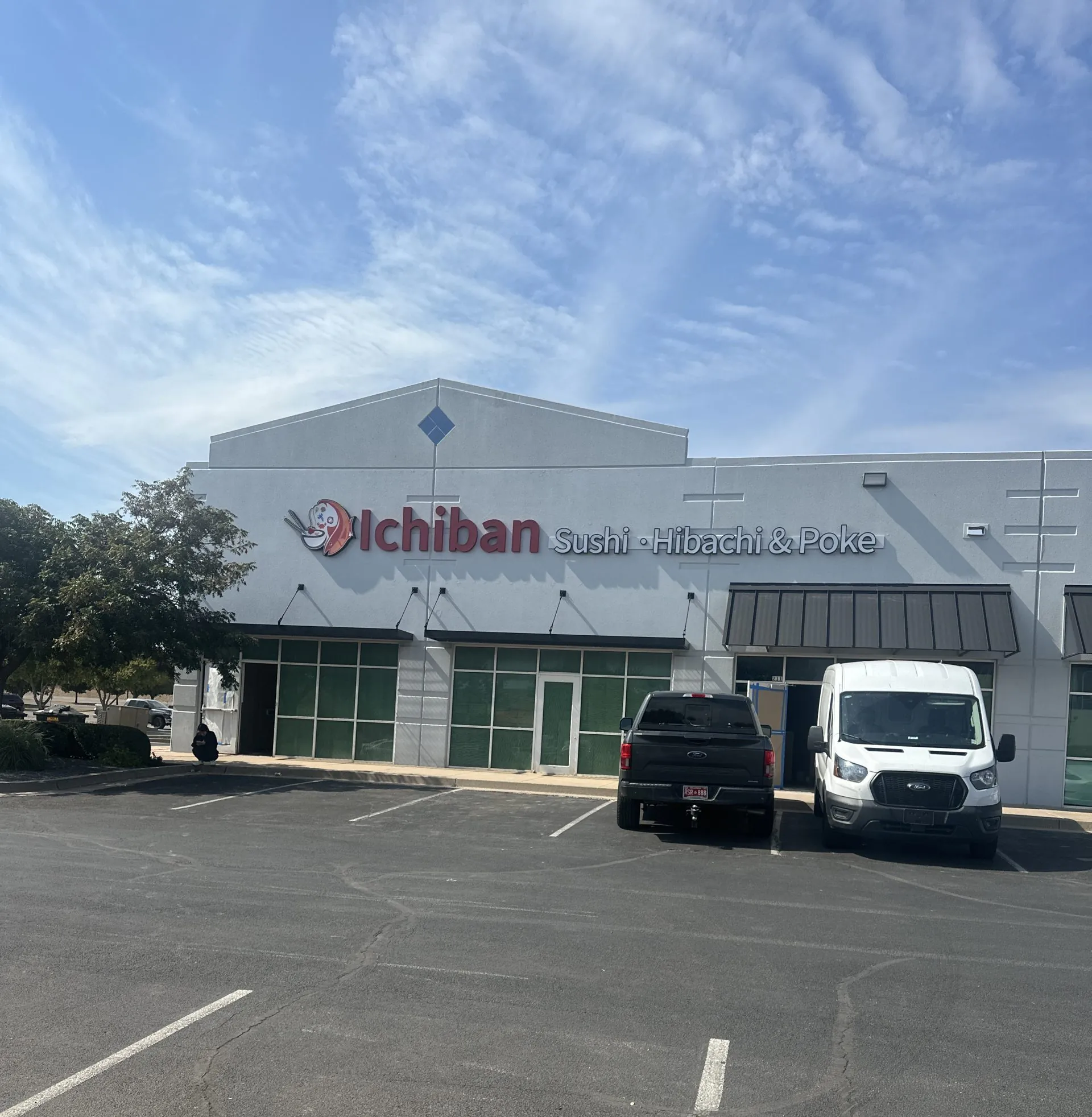 Exterior of Ichiban Sushi • Hibachi & Poke storefront with parking lot under a blue sky.